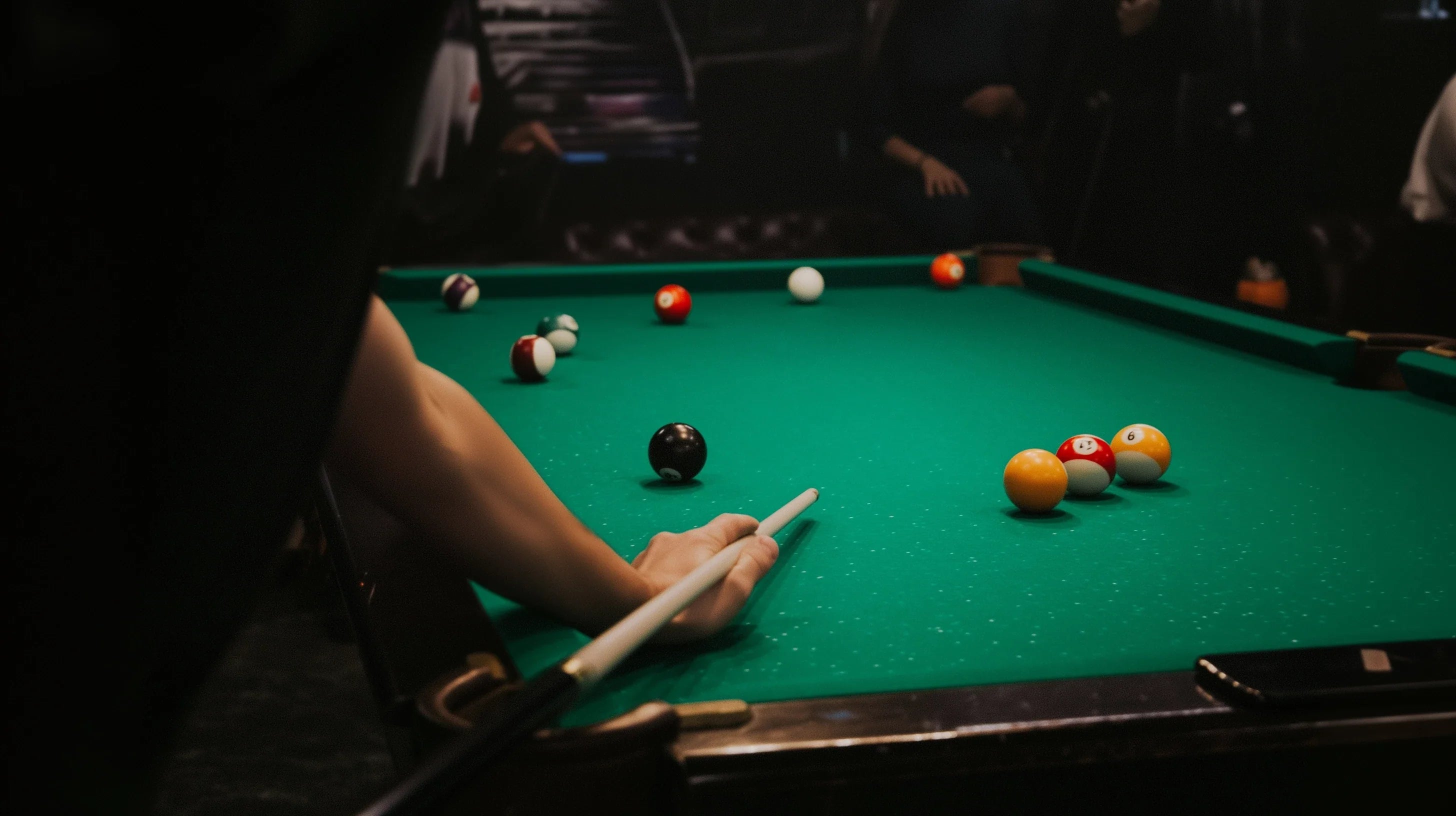 a pool player shooting at a green cloth table