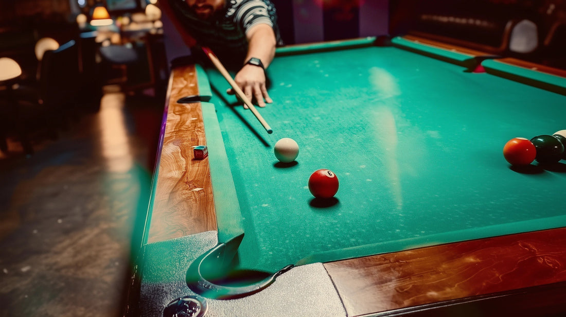 A man shooting at a pool table with green felt