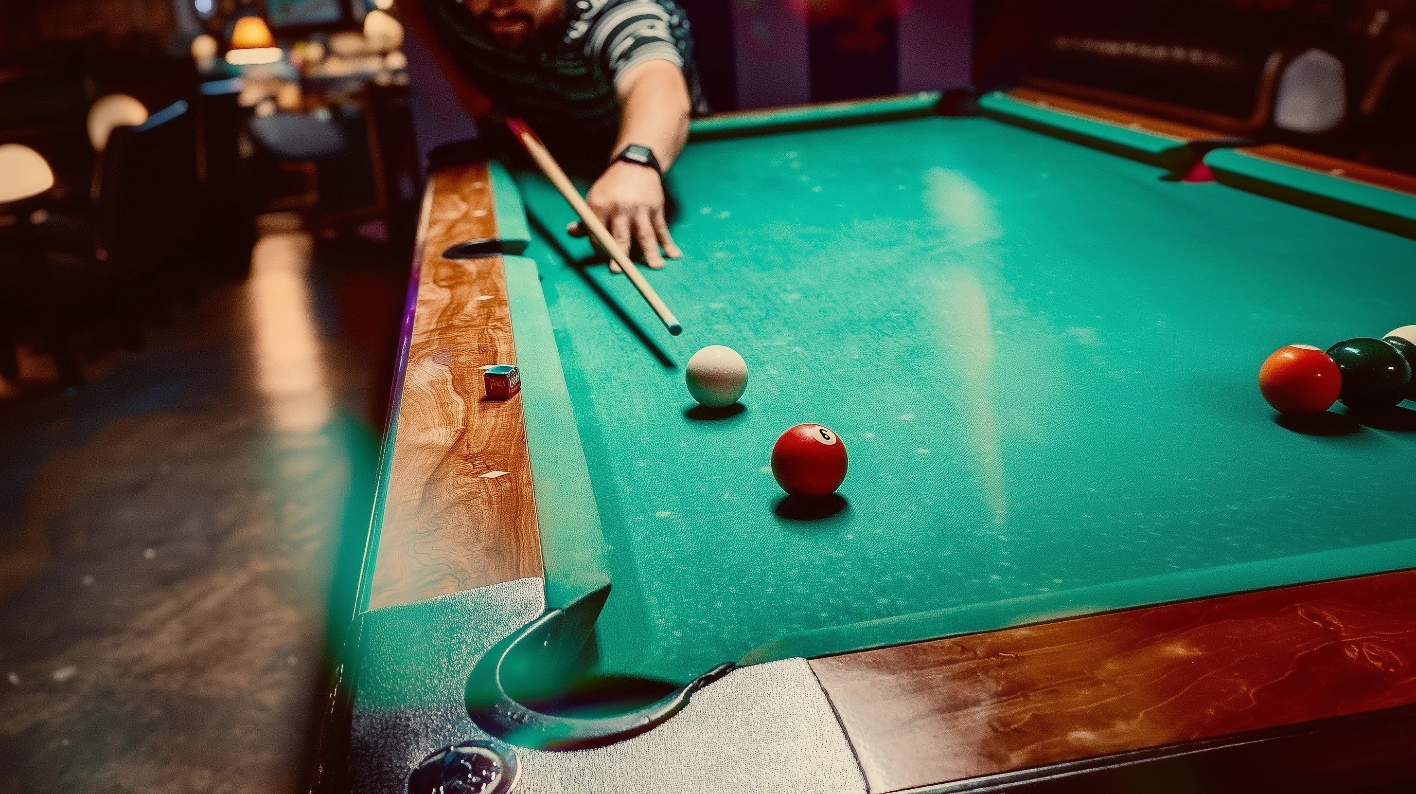 A man shooting at a pool table with green felt