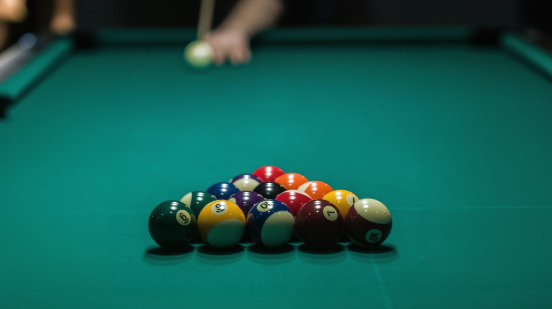 Rack of 15 billiard balls with a pool player in the background about to shoot