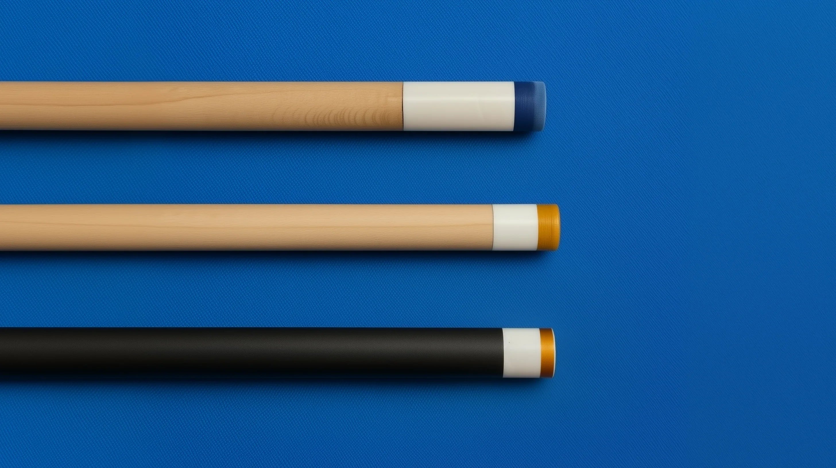 Three different styles of cue sticks on a blue cloth pool table surface