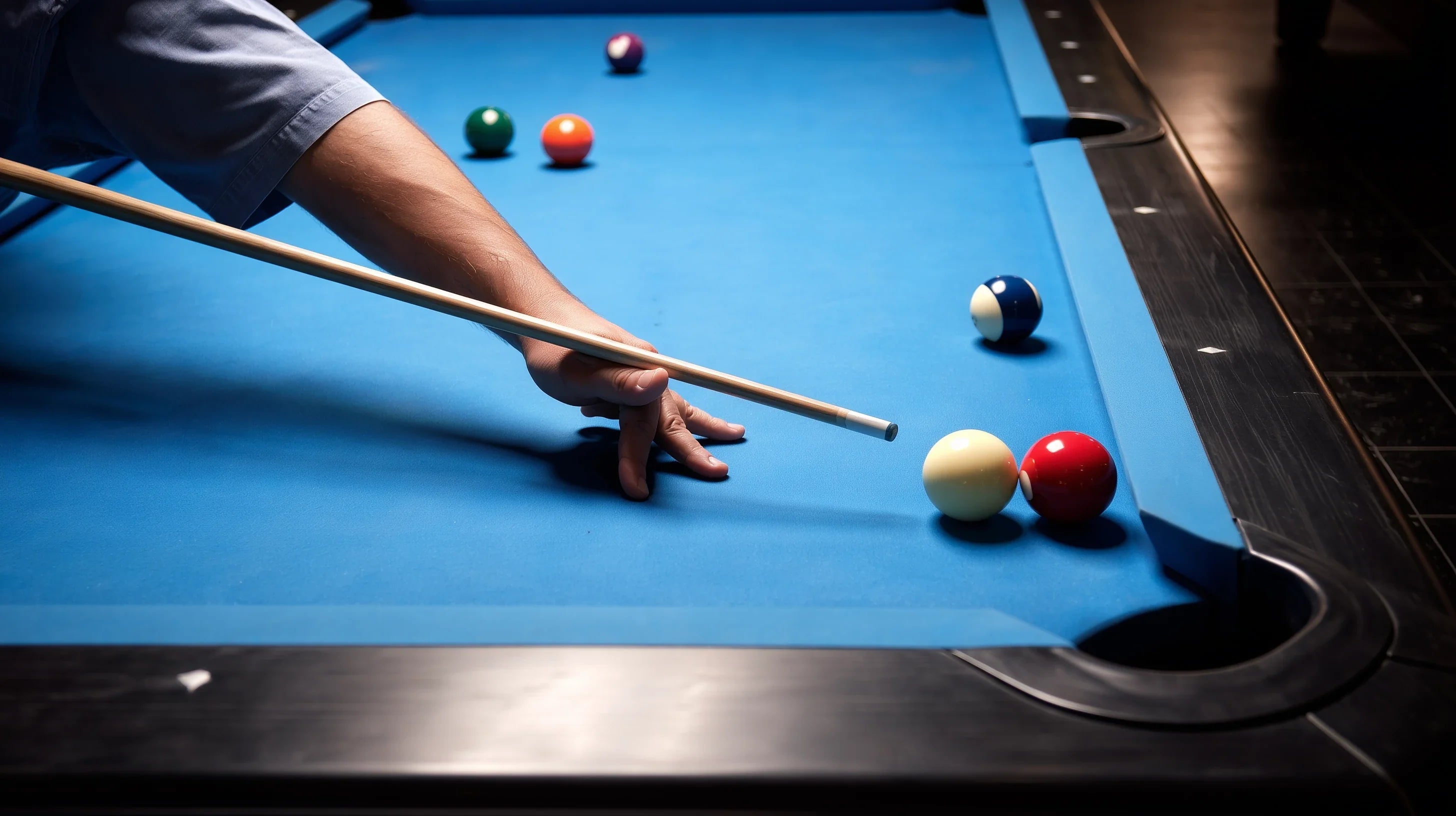 A man shooting a billiards shot on a blue cloth table