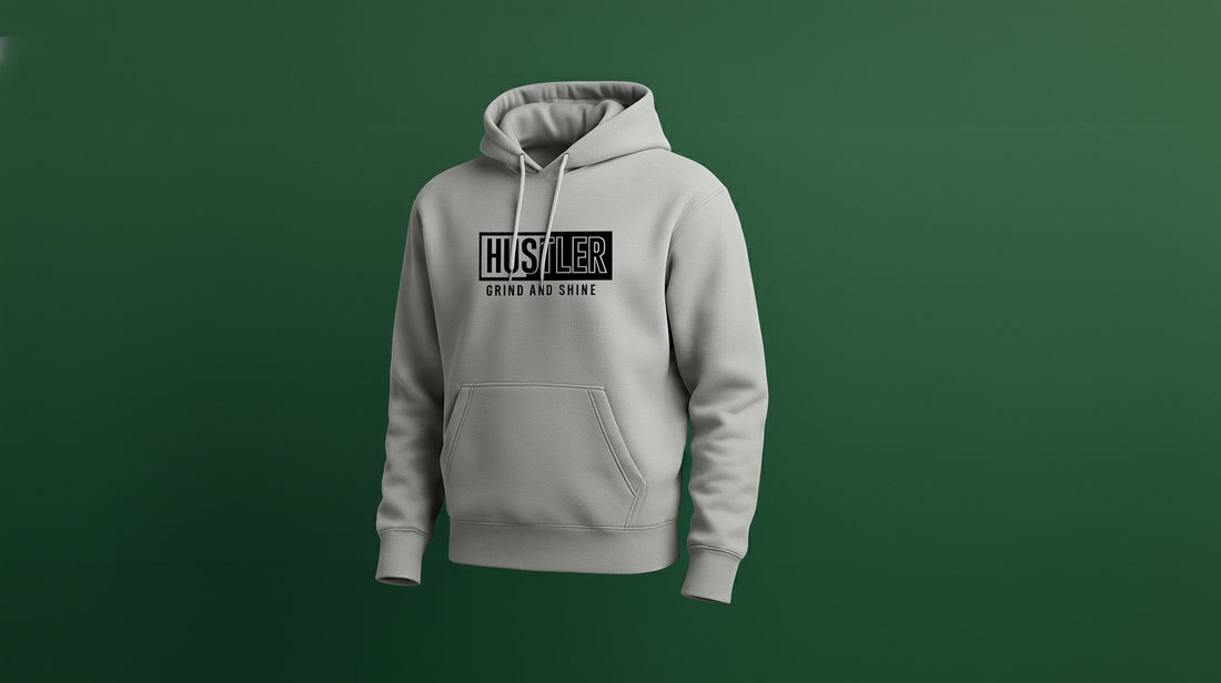 A sport grey hoodie with Hustler Grind and Shine on the front shown from a 3/4 perspective on a green backdrop